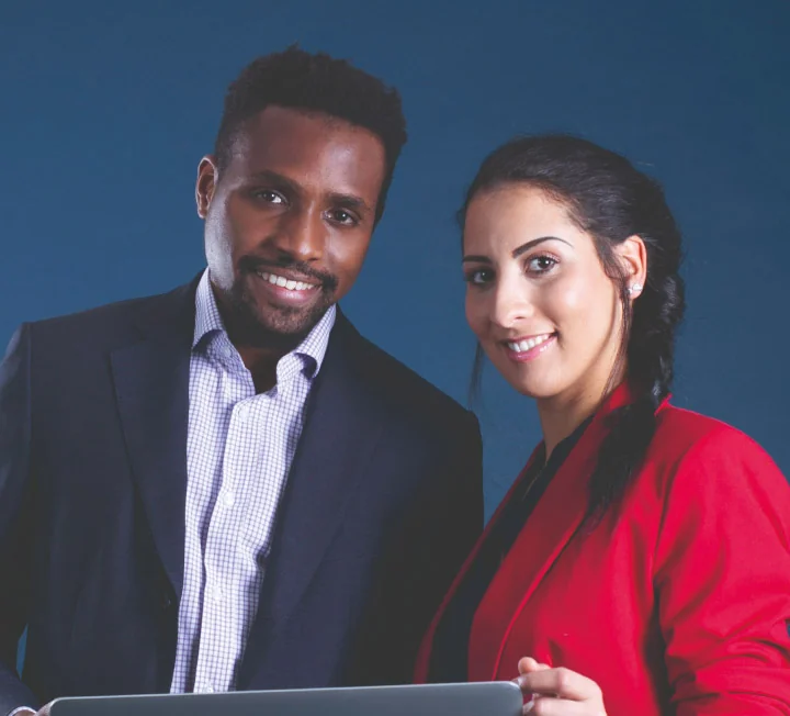 Un homme et une femme en tenue professionnelle sourient sur fond bleu.